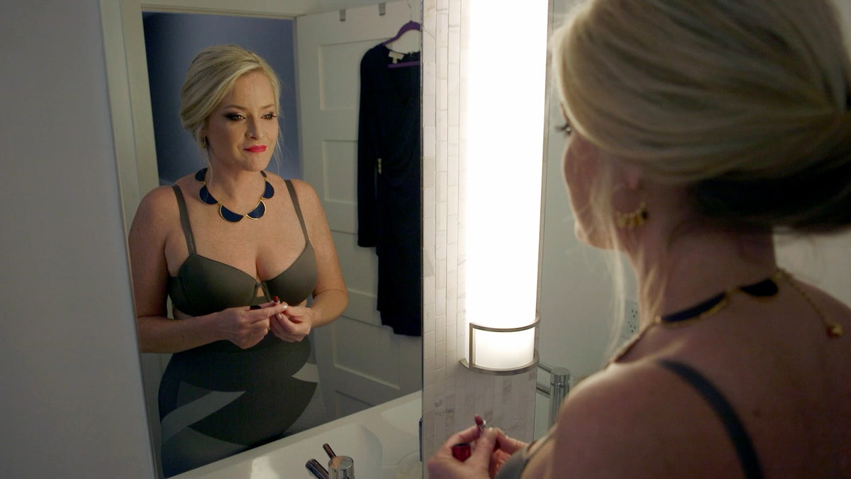 Woman wearing Mass & Slim shapewear shorts looking in a mirror