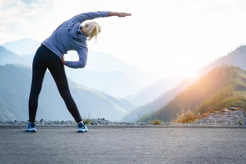 Woman stretching and wearing compression leggings to help blood flow and circulation