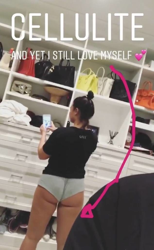 Woman taking a mirror selfie in underwear with visible cellulite, standing confidently in front of a closet. Text overlay reads "CELLULITE AND YET, I STILL LOVE MYSELF" with a pink heart.